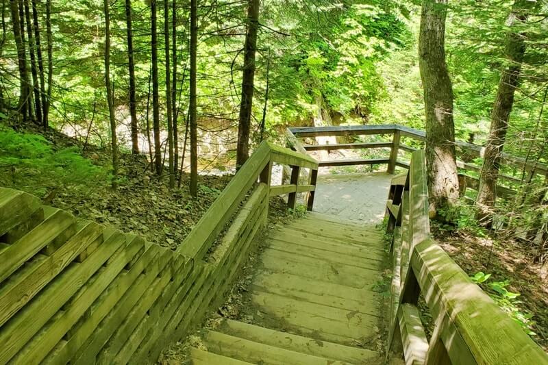 Sable Falls Trail boardwalk stairs hiking to waterfalls. forest waterfall hike in Pictured Rocks. UP Michigan travel blog