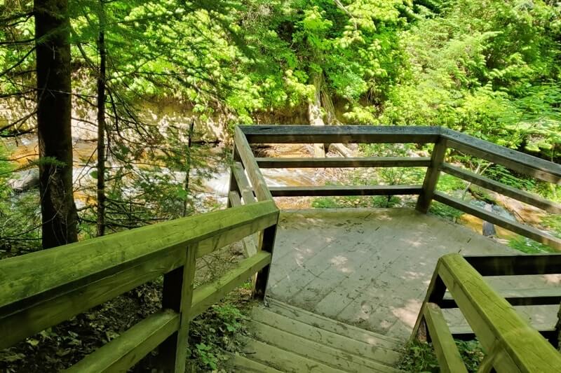 Sable Falls Trail boardwalk stairs hiking to waterfalls. forest waterfall hike in Pictured Rocks. UP Michigan travel blog