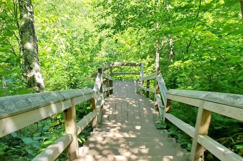 Sable Falls Trail boardwalk stairs hiking to waterfalls. forest waterfall hike in Pictured Rocks. UP Michigan travel blog