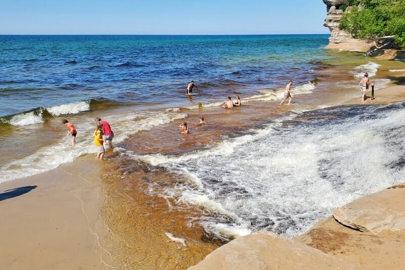 Things to do in Pictured Rocks National Lakeshore park: chapel beach falls, waterfalls flowing into lake superior. UP Michigan travel blog
