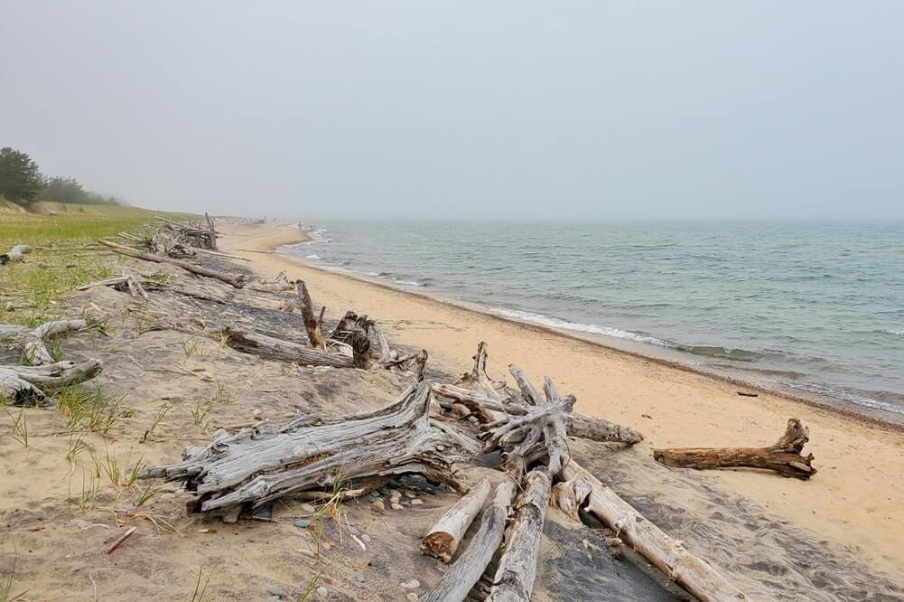 Whitefish Point beach near whitefish point lighthouse. Lake Superior lighthouse shipwreck coast. upper peninsula. up michigan travel blog