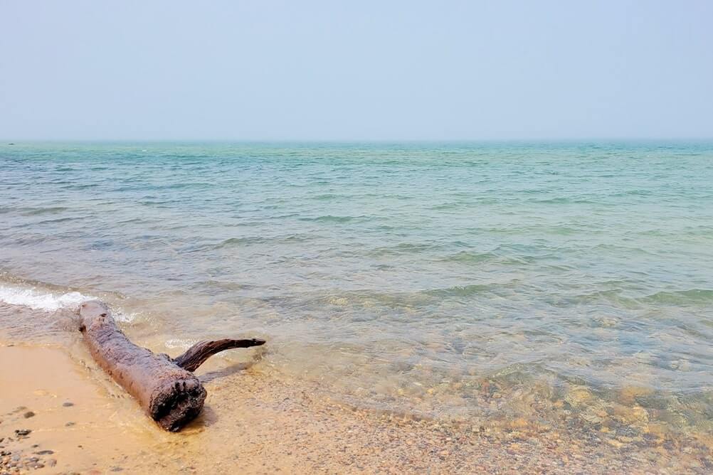 Whitefish Point beach near whitefish point lighthouse. Lake Superior lighthouse shipwreck coast. upper peninsula. up michigan travel blog