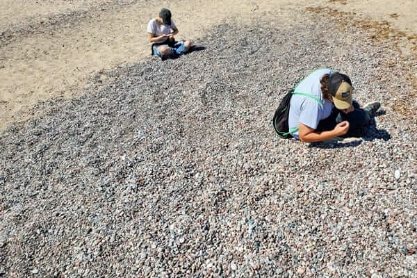 Grand Marais lighthouse beach near outer lighthouse pier. Lake Superior agate rocks. grand marais agate beach. colorful rocks. up michigan travel blog
