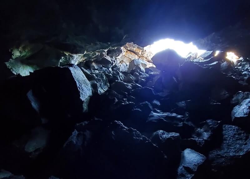 climbing out of Dewdrop Cave lava tube. dewsdrop cave opening. craters of the moon. idaho travel blog