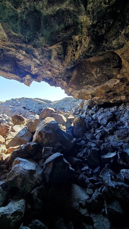 climbing out of Dewdrop Cave lava tube. dewsdrop cave opening. craters of the moon. idaho travel blog