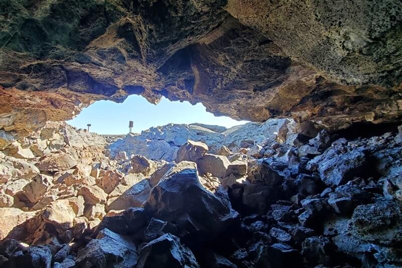climbing out of Dewdrop Cave lava tube. dewsdrop cave opening. craters of the moon. idaho travel blog