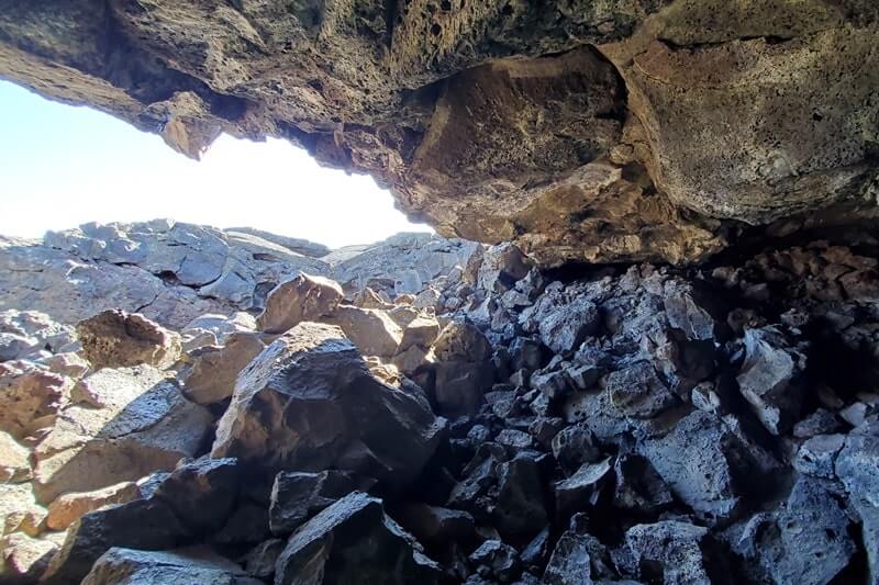 climbing out of Dewdrop Cave lava tube. dewsdrop cave opening. craters of the moon. idaho travel blog