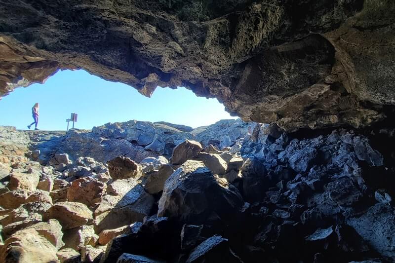 climbing out of Dewdrop Cave lava tube. dewsdrop cave opening. craters of the moon. idaho travel blog