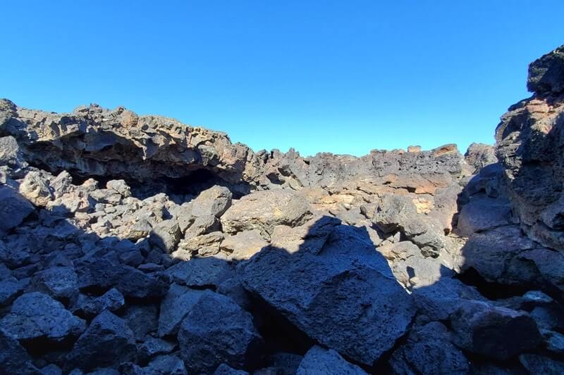 climbing out of Dewdrop Cave lava tube. dewsdrop cave opening. craters of the moon. idaho travel blog
