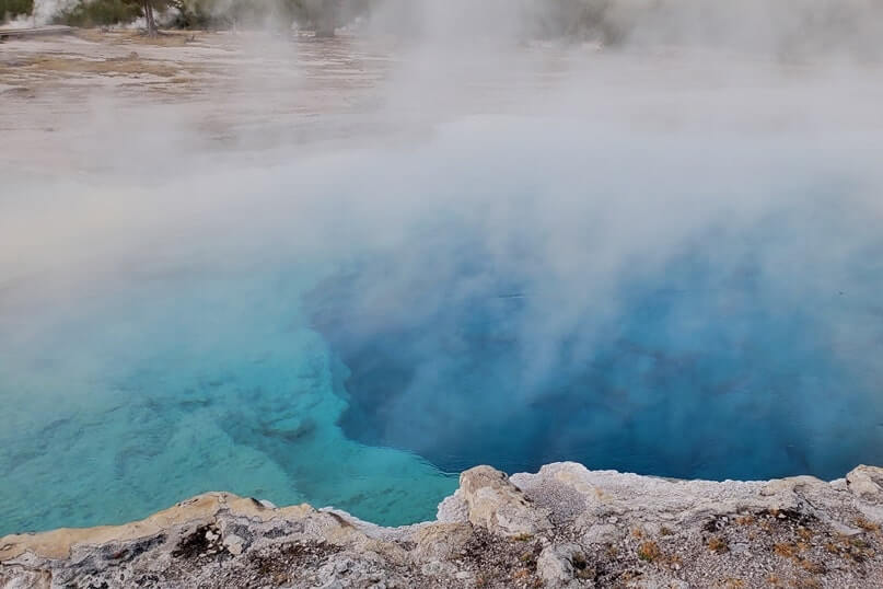 sapphire pool: bright blue yellowstone hot spring in biscuit basin. wyoming travel blog