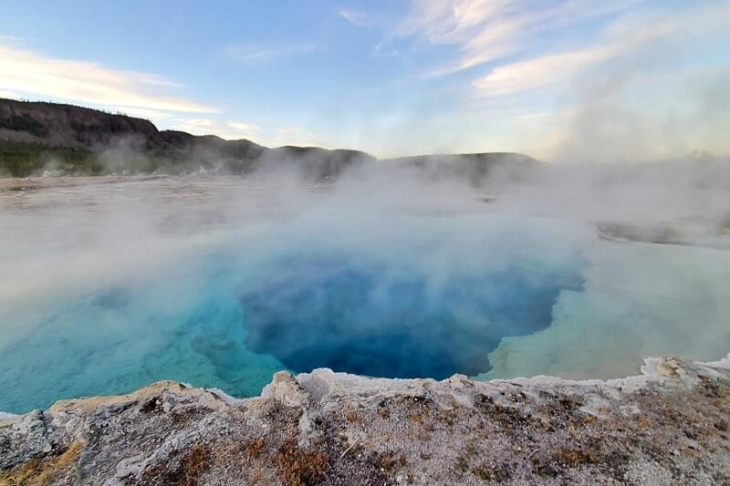 sapphire pool: bright blue yellowstone hot spring in biscuit basin. wyoming travel blog