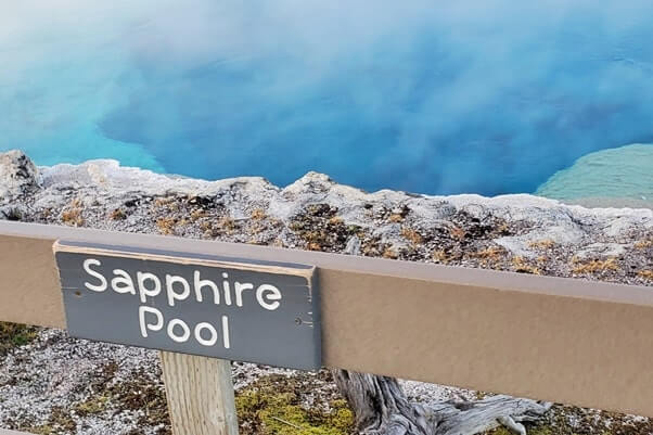 colorful blue hot spring in biscuit basin near old faithful: sapphire pool in yellowstone national park. wyoming travel blog