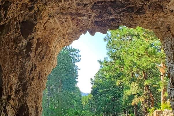CC Gideon Tunnel view of Mount Rushmore on Iron Mountain Road. Driving through Iron Mountain Road tunnel to see Mount Rushmore. black hills national forest. south dakota travel blog