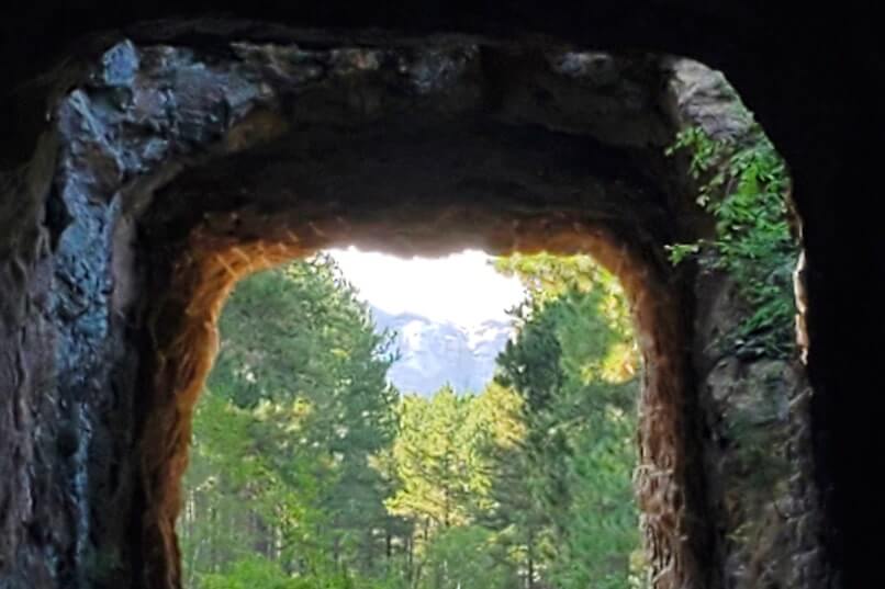 CC Gideon Tunnel view of Mount Rushmore on Iron Mountain Road. Driving through Iron Mountain Road tunnel to see Mount Rushmore. black hills national forest. south dakota travel blog
