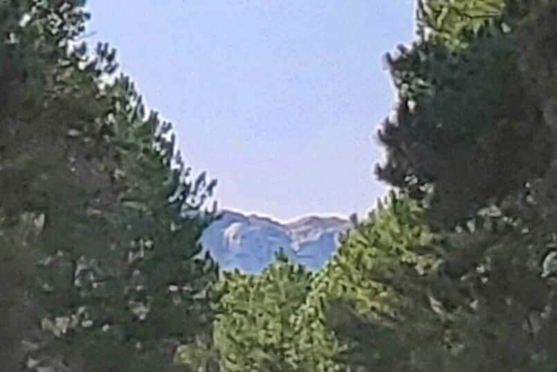 CC Gideon Tunnel view of Mount Rushmore on Iron Mountain Road. Driving through Iron Mountain Road tunnel to see Mount Rushmore. black hills national forest. south dakota travel blog