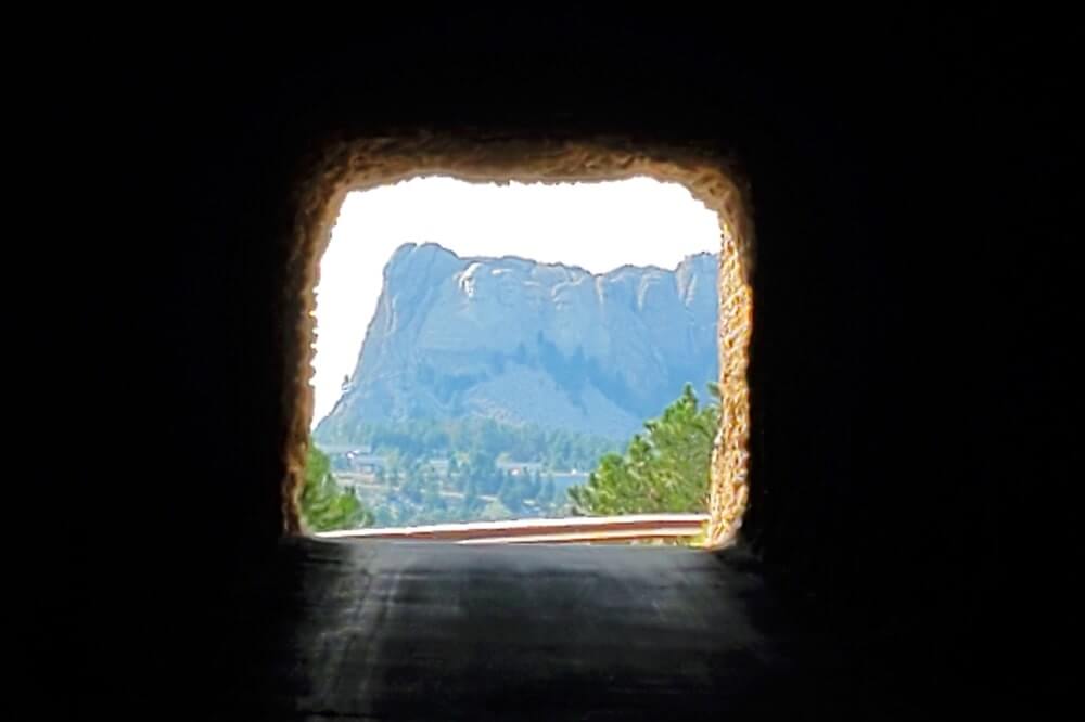best tunnel view of mount rushmore: driving through iron mountain road tunnel. driving through doane robinson tunnel. mount rushmore tunnel view.black hills national forest drive. south dakota travel blog
