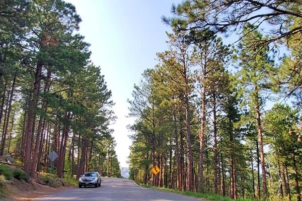Driving with mount rushmore views on iron mountain road away from scovel johnson tunnel. south dakota travel blog.
