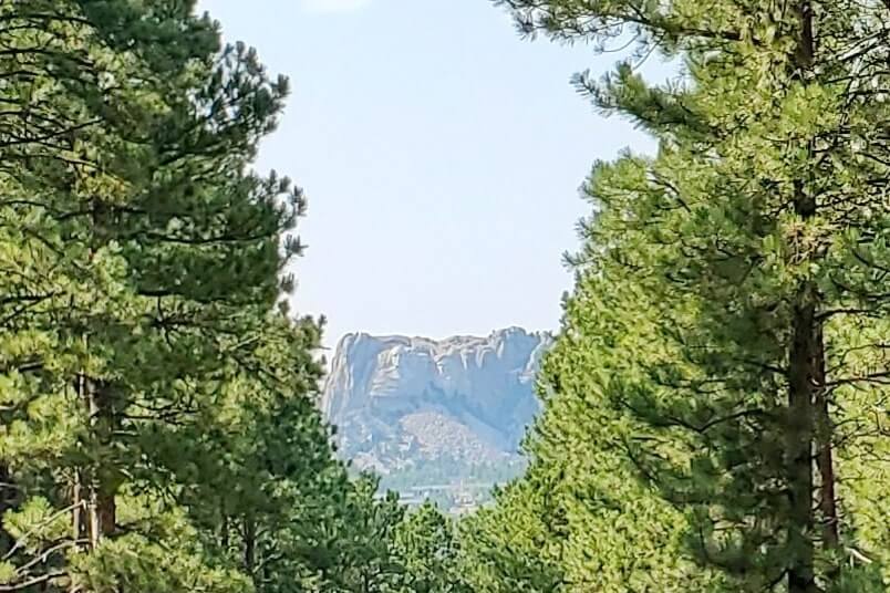 Driving with mount rushmore views on iron mountain road away from scovel johnson tunnel. south dakota travel blog.