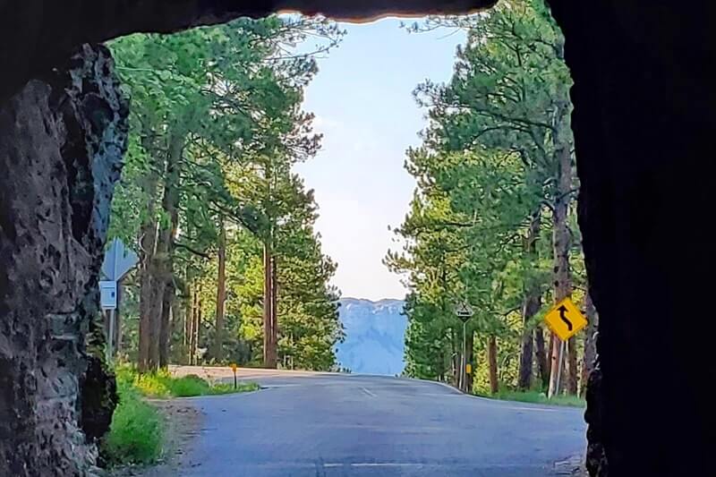 Scovel Johnson Tunnel view of Mount Rushmore on Iron Mountain Road. Driving through Iron Mountain Road tunnel to see Mount Rushmore. black hills national forest. south dakota travel blog